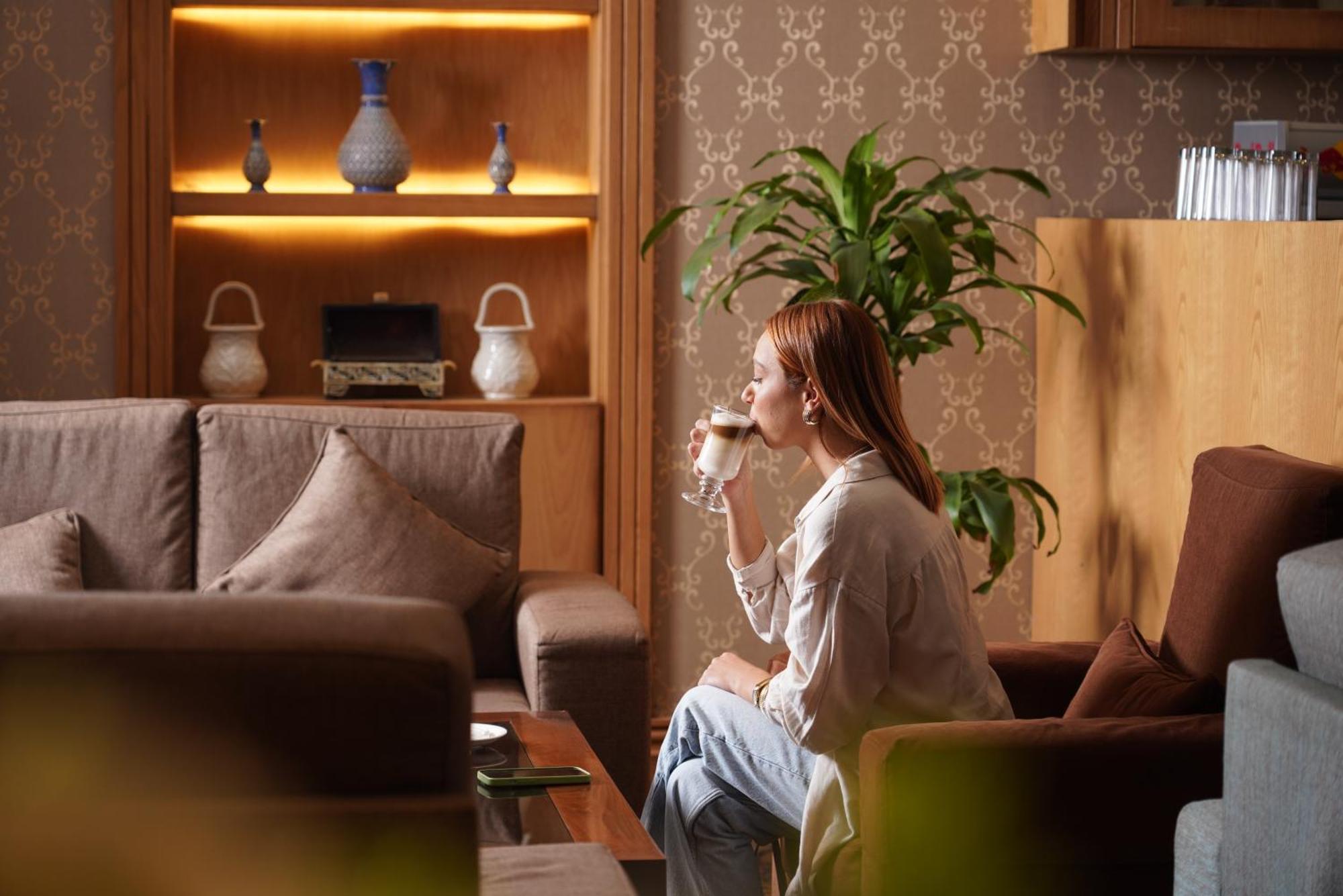 Thousand Nights Hotel Amán Exterior foto A woman drinking coffee